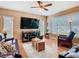 Inviting living room featuring wood floors, natural light, and a ceiling fan for added comfort at 28402 Openfield Loop, Wesley Chapel, FL 33543