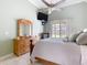 Sunlit primary bedroom features a bed, dresser, and a view to the outdoors at 28402 Openfield Loop, Wesley Chapel, FL 33543