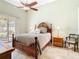 Well-lit primary bedroom with a large bed, a ceiling fan, and tile flooring at 28402 Openfield Loop, Wesley Chapel, FL 33543