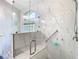 Close up of marble tiled glass shower with built-in bench, grab bar and multiple shower heads at 28402 Openfield Loop, Wesley Chapel, FL 33543