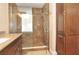 Bathroom featuring a tiled shower, glass door, and dark wood cabinetry, blending style and functionality at 3189 Roxmere Dr, Palm Harbor, FL 34685