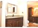 Bathroom with granite countertop, dark wood cabinets, and large mirror, offering a luxurious and functional space at 3189 Roxmere Dr, Palm Harbor, FL 34685