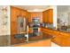 Modern kitchen featuring stainless steel appliances, granite countertops, and wood cabinetry at 3189 Roxmere Dr, Palm Harbor, FL 34685