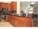 Kitchen with stainless steel appliances, granite countertops and an adjacent breakfast bar overlooking the living room at 3189 Roxmere Dr, Palm Harbor, FL 34685