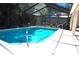 Sparkling screened-in swimming pool surrounded by a spacious patio and lush landscaping at 3189 Roxmere Dr, Palm Harbor, FL 34685