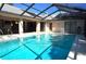 Inviting swimming pool with covered patio, outdoor furniture, and screened in from the sun at 3189 Roxmere Dr, Palm Harbor, FL 34685