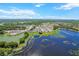 Aerial view of a community with lakes and green spaces, featuring many houses at 36541 Night Strawberry Ct, Dade City, FL 33525