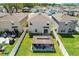 Aerial view of the backyard, featuring a covered patio with outdoor furniture, a white fence, and green grass at 36541 Night Strawberry Ct, Dade City, FL 33525