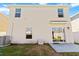 Back exterior elevation featuring an open yard, sliding glass doors, two windows, and a patio at 36541 Night Strawberry Ct, Dade City, FL 33525
