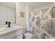 Beach-themed bathroom with single sink vanity, a toilet, and a shower/tub with a decorative shower curtain at 36541 Night Strawberry Ct, Dade City, FL 33525