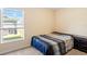 Simple bedroom featuring carpeted floors, a bed, a nightstand, and a window at 36541 Night Strawberry Ct, Dade City, FL 33525