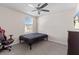 Neutral bedroom with a ceiling fan, window, bed, computer chair, dresser, and wall mounted TV at 36541 Night Strawberry Ct, Dade City, FL 33525