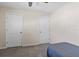 Bedroom with neutral walls, carpet floors, and two white doors, creating a cozy and functional space at 36541 Night Strawberry Ct, Dade City, FL 33525
