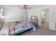 Spacious bedroom with ceiling fan, adjacent bathroom, and a large TV at 36541 Night Strawberry Ct, Dade City, FL 33525