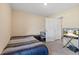 A simple bedroom featuring carpeted floors, a bed, a desk, and a doorway to another room at 36541 Night Strawberry Ct, Dade City, FL 33525