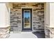 Stylish front door with stone surround and transom window offering curb appeal at 36541 Night Strawberry Ct, Dade City, FL 33525
