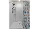 Modern shower featuring a rainfall showerhead, white tile, and colorful shower curtain at 36541 Night Strawberry Ct, Dade City, FL 33525