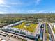 Aerial view of the condo community, with lush greenery, tennis courts, pool and expansive parking at 4720 Locust Ne St # 206, St Petersburg, FL 33703