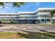 Three-story condo building with parking and a blue exterior with white lattice balconies under a partly cloudy sky at 4720 Locust Ne St # 206, St Petersburg, FL 33703