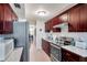This kitchen features ample dark wood cabinetry, stainless steel appliances and modern white subway tile backsplash at 4720 Locust Ne St # 206, St Petersburg, FL 33703