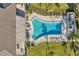 Aerial view of a community pool with ample seating, surrounded by lush landscaping and a secure fence at 4720 Locust Ne St # 206, St Petersburg, FL 33703