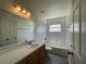 Bathroom featuring a vanity, mirror, tile surround bathtub, and vinyl flooring at 4731 Portobello Cir, Valrico, FL 33596