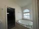 This Primary bath has a soaking tub, a frosted window, and leads into the bedroom at 4731 Portobello Cir, Valrico, FL 33596