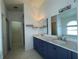 Bathroom featuring double sink vanity, marble countertop, modern fixtures, and a walk-in closet at 4731 Portobello Cir, Valrico, FL 33596