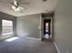 Bedroom with a ceiling fan, window for natural light, and a door leading to the backyard at 4731 Portobello Cir, Valrico, FL 33596