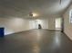 A large garage with white concrete block walls and gray painted concrete floors at 4731 Portobello Cir, Valrico, FL 33596