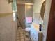 Bathroom view showing classic tilework, a shower with sliding door, and a vanity area, all needing repair at 613 Chestnut St, Oldsmar, FL 34677
