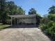 Carport featuring an overhead shelter, and a surrounding concrete parking area, but needs cleaning and some repair at 613 Chestnut St, Oldsmar, FL 34677