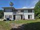 Backyard elevation of the two-story home, showing the patio, and requiring repair and renovation at 613 Chestnut St, Oldsmar, FL 34677