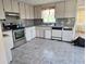 Outdated kitchen cabinets and stainless steel appliances needing work at 613 Chestnut St, Oldsmar, FL 34677
