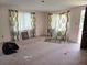 Living room needing work, with large windows, patterned curtains, and pink carpet at 613 Chestnut St, Oldsmar, FL 34677