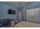 Cozy bedroom featuring cool blue walls, desk area, large closet, and comfortable decor at 6312 Lantern View Pl, Apollo Beach, FL 33572