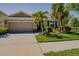 Charming home with a two-car garage, mature landscaping, and beautiful curb appeal on a sunny day at 6312 Lantern View Pl, Apollo Beach, FL 33572