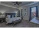 Beautiful main bedroom featuring a tray ceiling, wood-look accent wall, large windows, and carpeted floors at 6312 Lantern View Pl, Apollo Beach, FL 33572