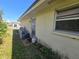 Side view of the house with utilities and plants nearby at 704 Lemonwood Dr, Oldsmar, FL 34677