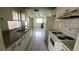 Functional kitchen with tile floors, white appliances, and a double sink at 704 Lemonwood Dr, Oldsmar, FL 34677