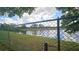 Picturesque view of a pond through a chain-link fence, showcasing a serene waterfront at 704 Lemonwood Dr, Oldsmar, FL 34677