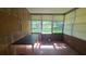 Cozy sunroom featuring wood paneling and several windows at 704 Lemonwood Dr, Oldsmar, FL 34677