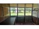 Enclosed sunroom featuring multiple windows offering natural light and views of the yard at 704 Lemonwood Dr, Oldsmar, FL 34677