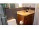 Bathroom featuring glass shower door, brown vanity with granite countertop and modern fixtures at 7321 San Moritz Dr, Port Richey, FL 34668