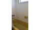 A yellow bathtub with matching tile walls, showcasing vintage style at 7321 San Moritz Dr, Port Richey, FL 34668