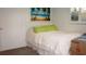 Bright bedroom with beach-themed art, white bedding, and a sunny window for a relaxing, coastal vibe at 7321 San Moritz Dr, Port Richey, FL 34668