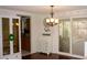 Charming dining area with a decorative chandelier, unique cabinet, and sliding glass doors at 7321 San Moritz Dr, Port Richey, FL 34668