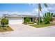 Charming one-story home featuring a well-manicured lawn, inviting walkway, and an attached two-car garage at 7321 San Moritz Dr, Port Richey, FL 34668