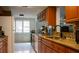 Well-lit kitchen with wood cabinets, granite countertops, tile backsplash, and tile floors at 7321 San Moritz Dr, Port Richey, FL 34668
