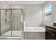 Bright bathroom featuring a tiled shower and soaking tub with natural light from the window at 7336 Bagley Cove Ct, Sun City Center, FL 33573